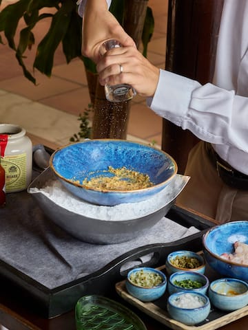 a person pouring seasoning into a bowl