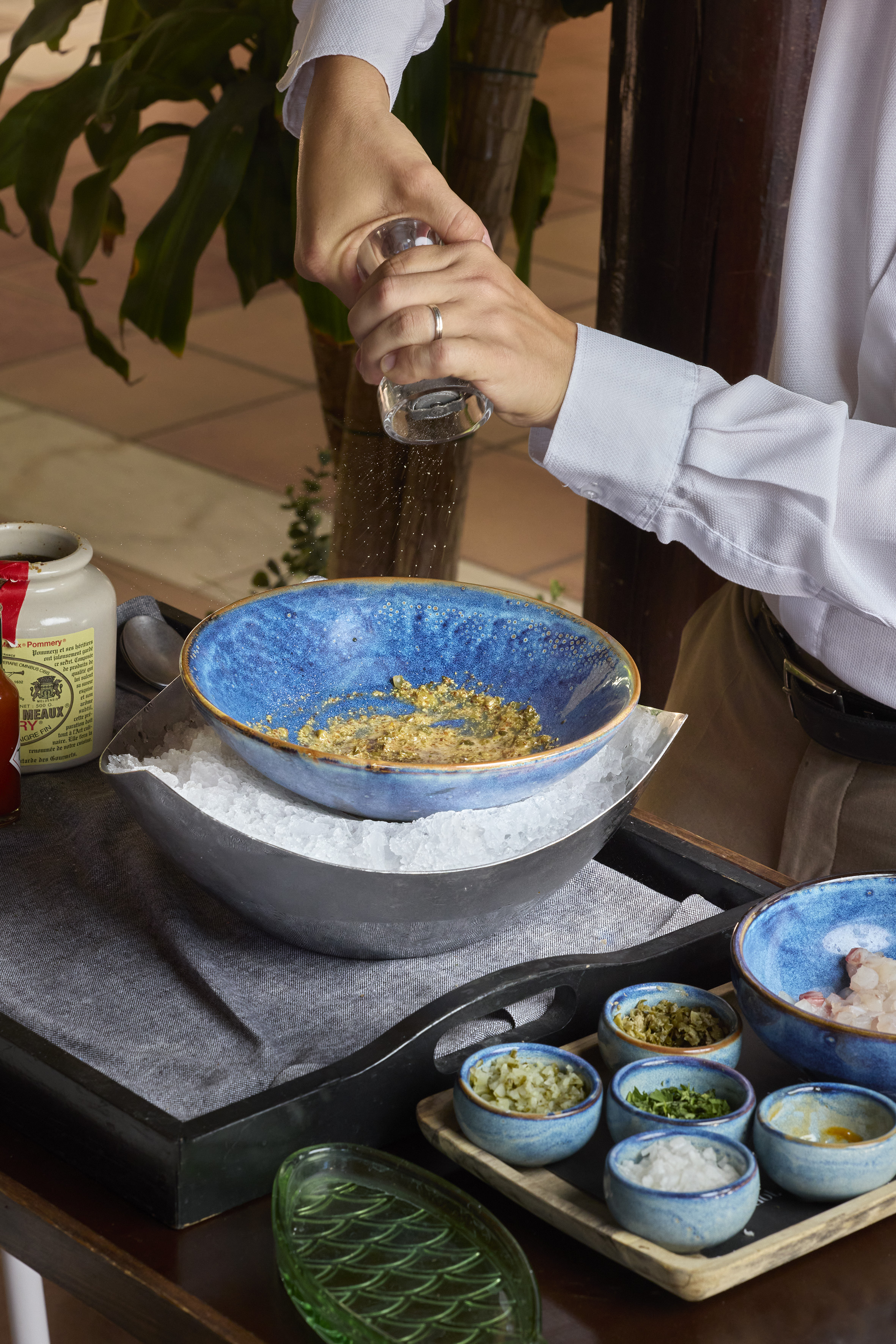 a person pouring seasoning into a bowl