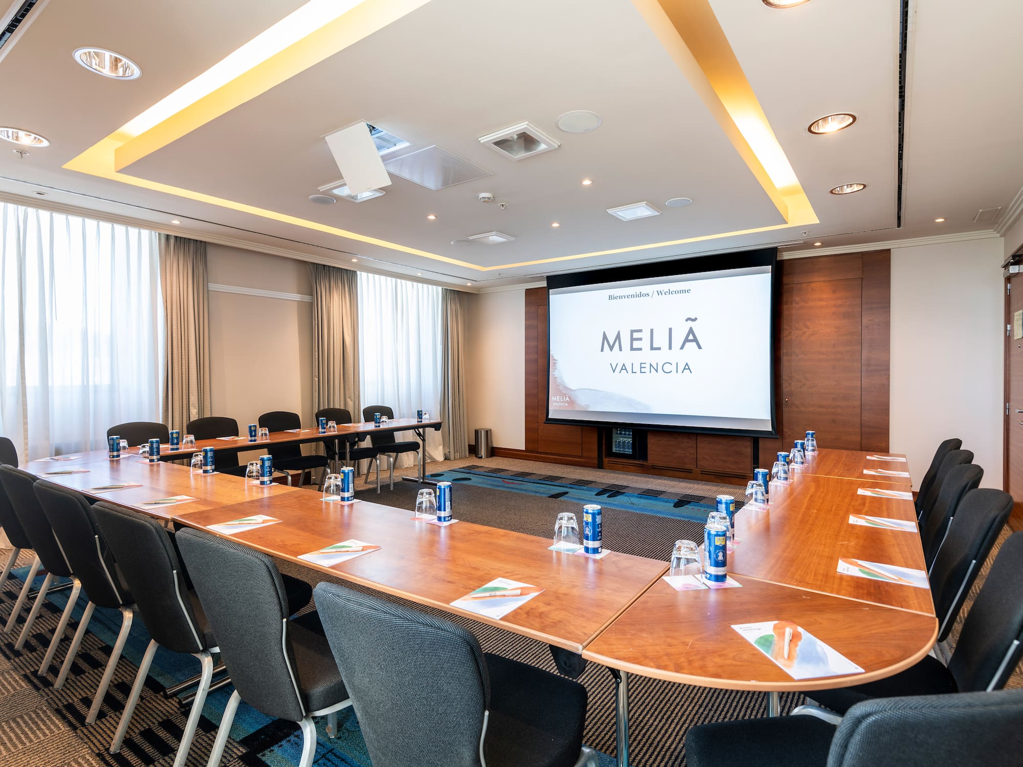 a room with a large screen and tables