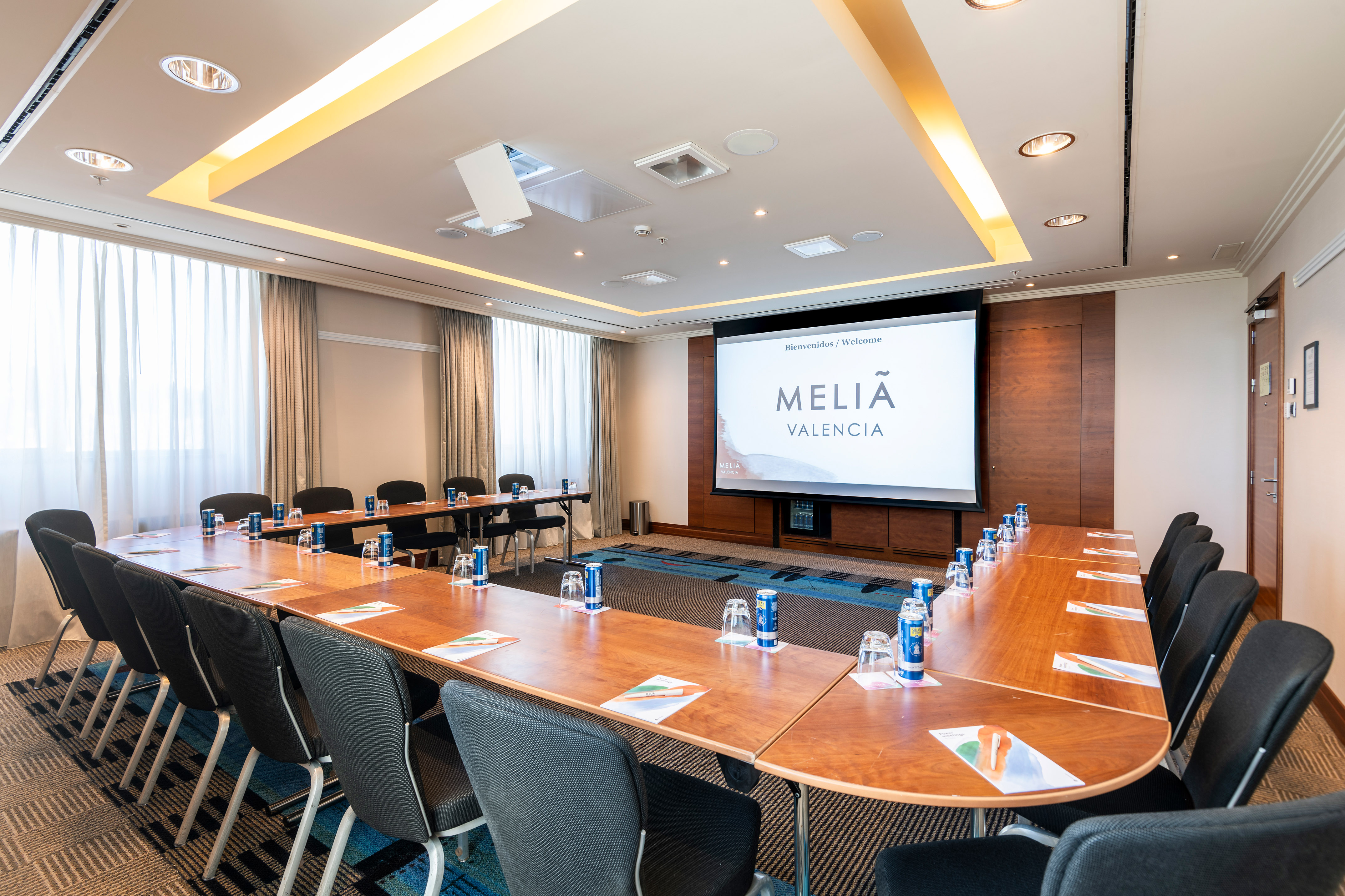 a room with a large screen and tables