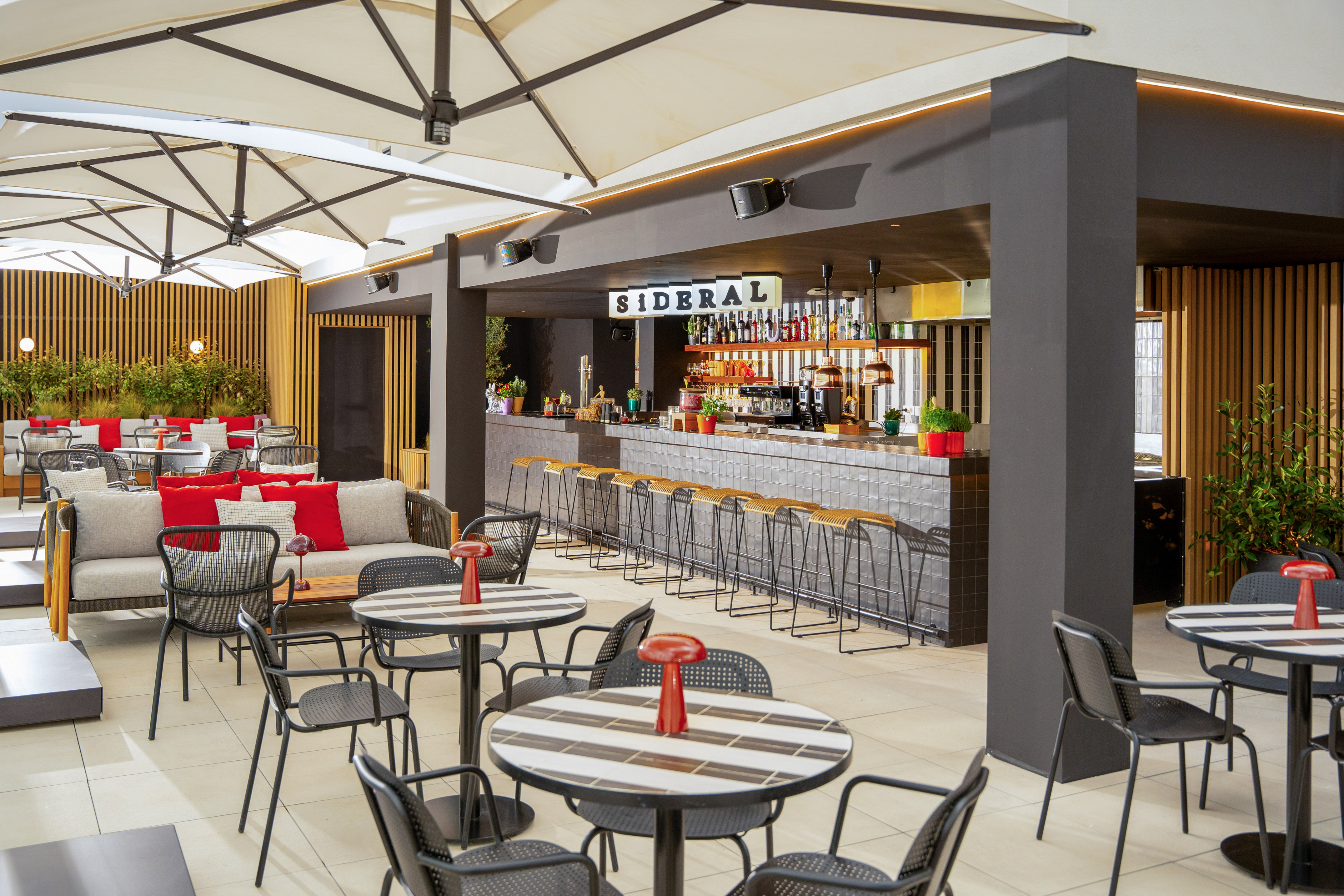 Outdoor restaurant patio with Sideral bar, modern seating, tables, and umbrellas.