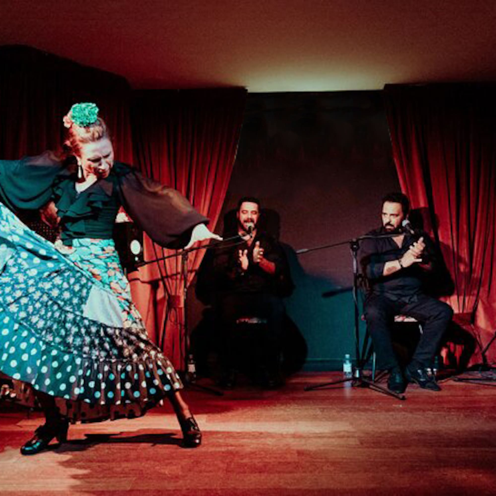 a woman dancing on a stage with a group of people in the background