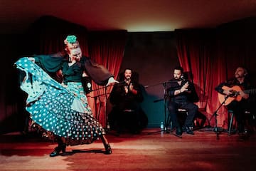 a woman dancing on a stage with a group of people in the background