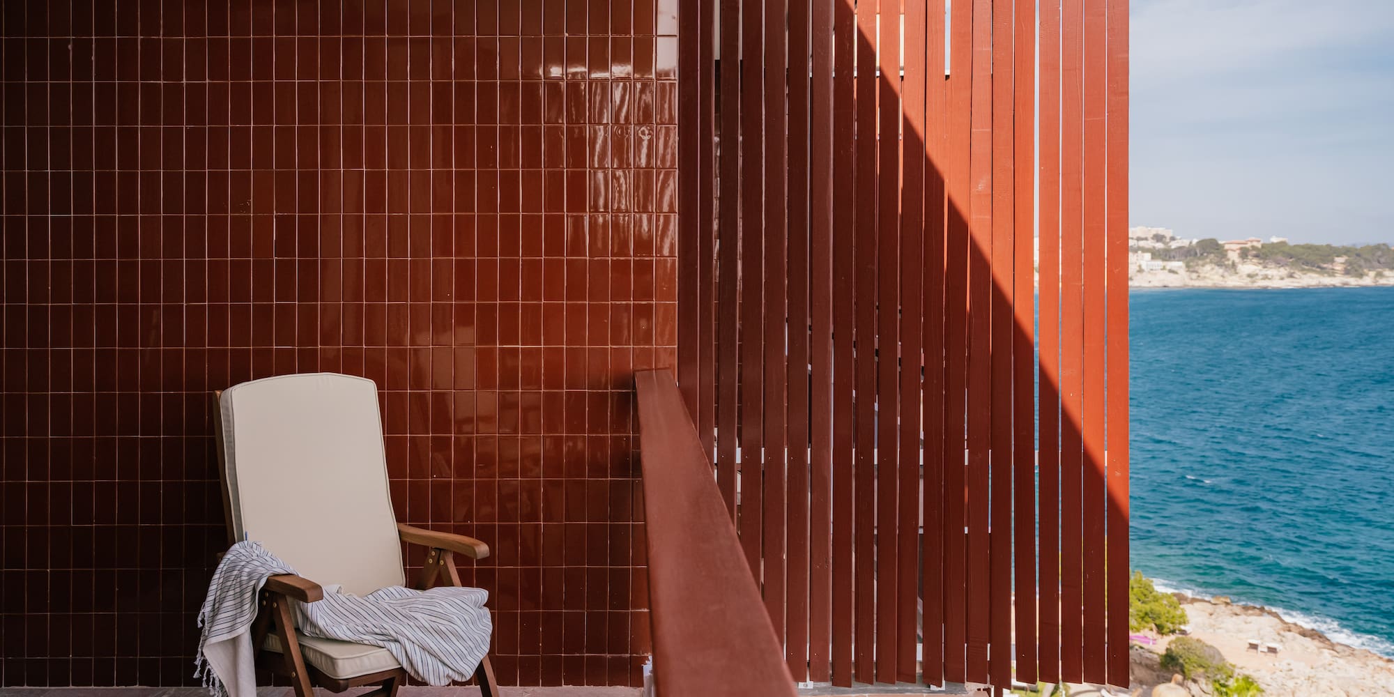 a chair on a balcony overlooking water
