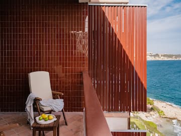 a chair on a balcony overlooking water