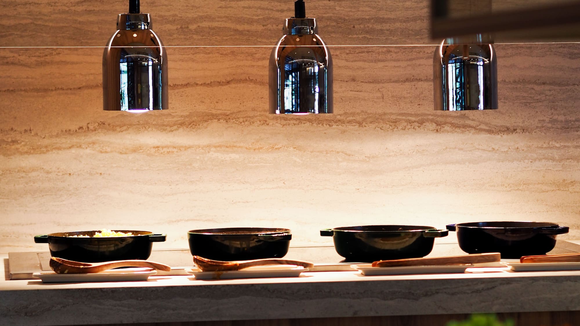 Buffet line with heat lamps, serving dishes, and stacked plates.