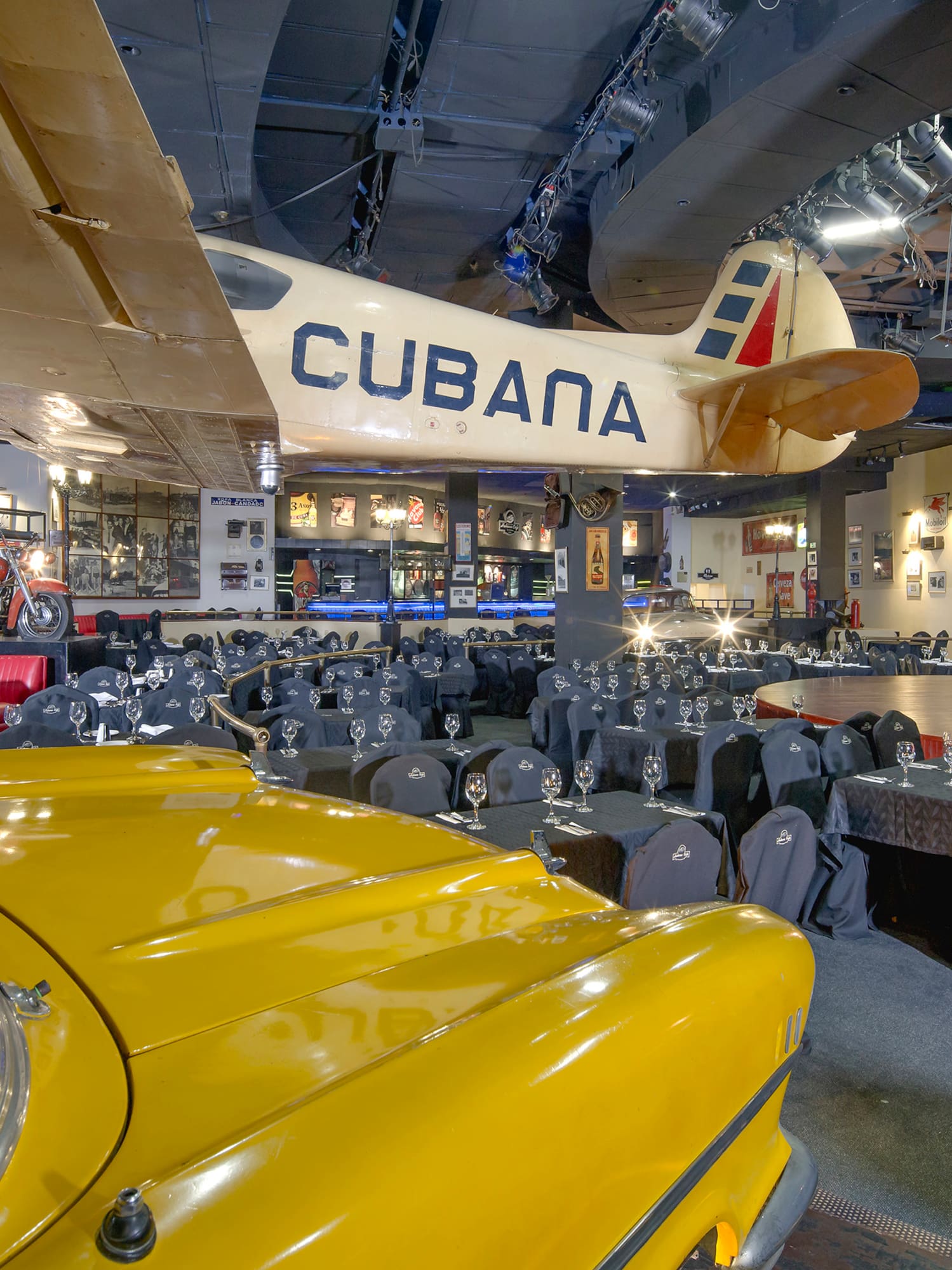 a room with tables and chairs and a yellow car