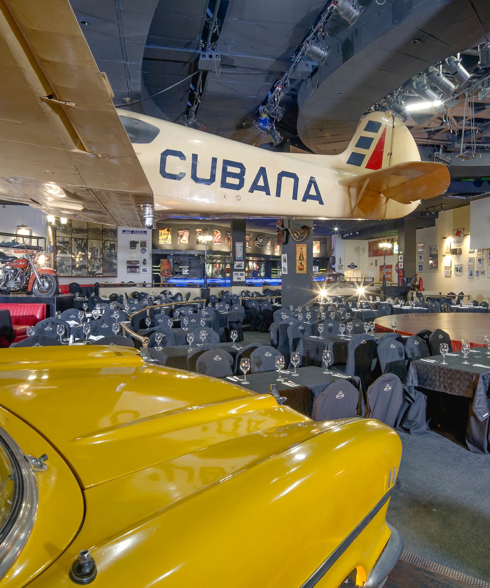 a room with tables and chairs and a yellow car