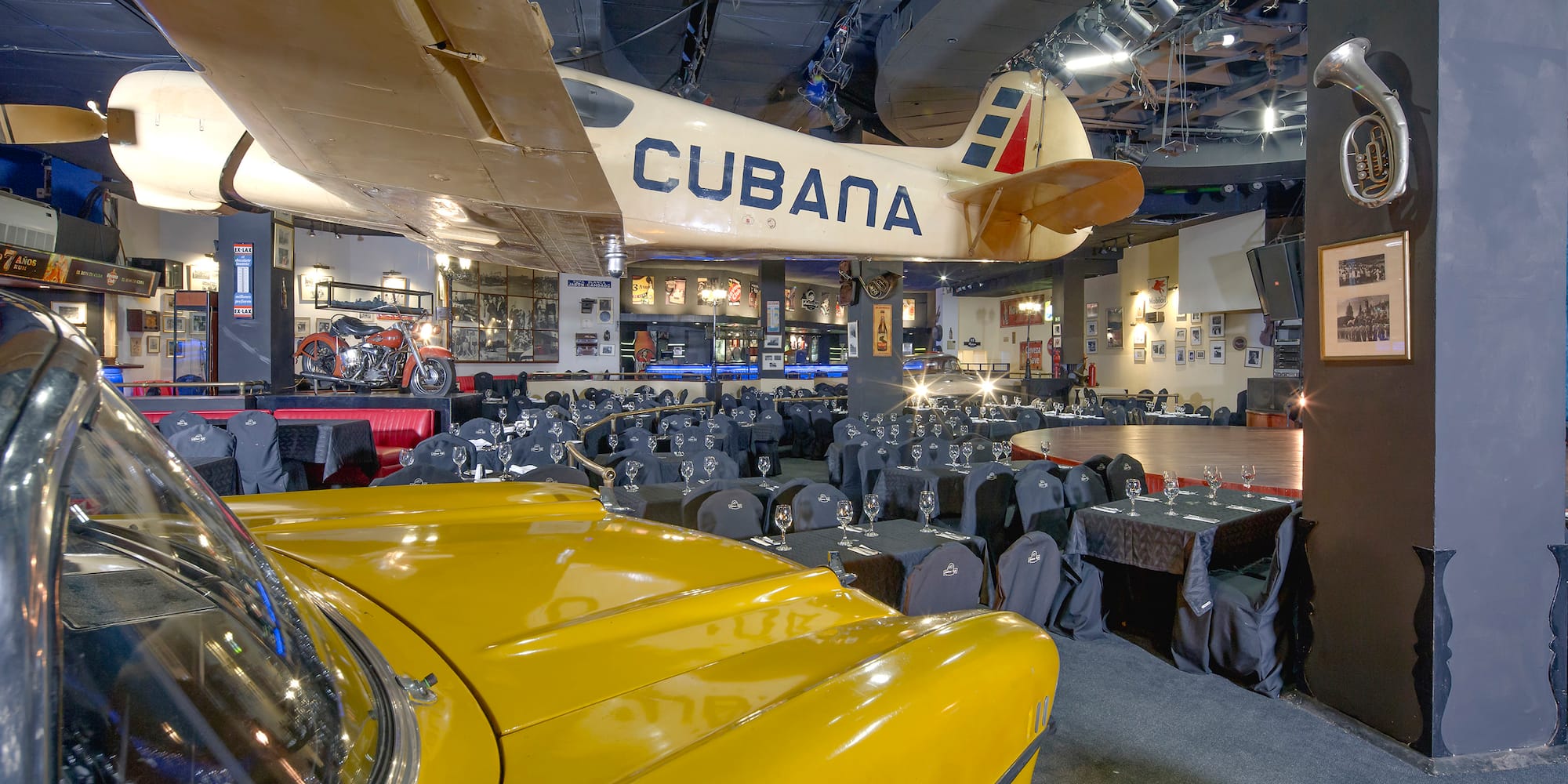 a room with tables and chairs and a yellow car