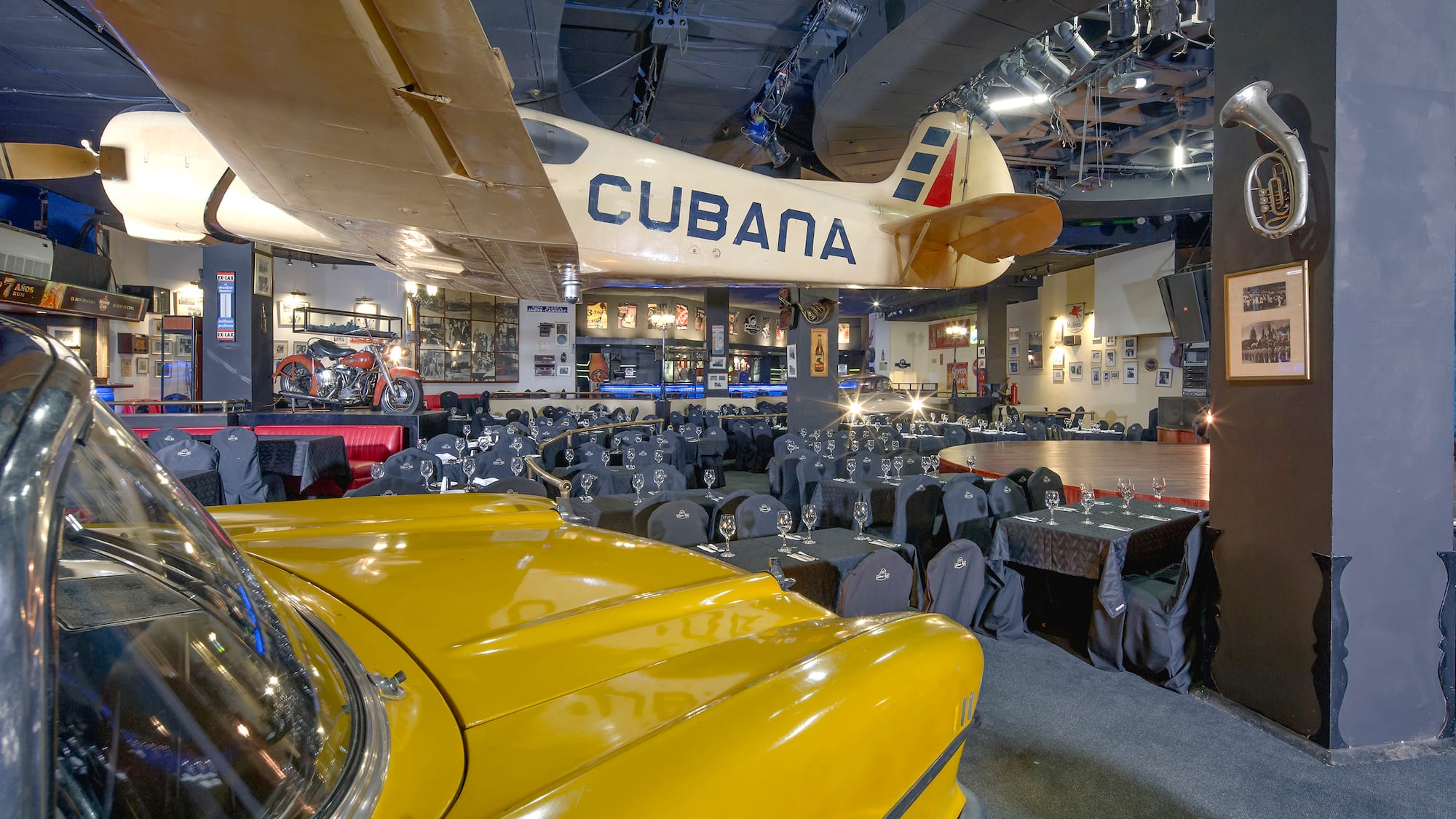 a room with tables and chairs and a yellow car