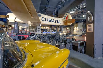 a room with tables and chairs and a yellow car