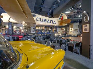 a room with tables and chairs and a yellow car
