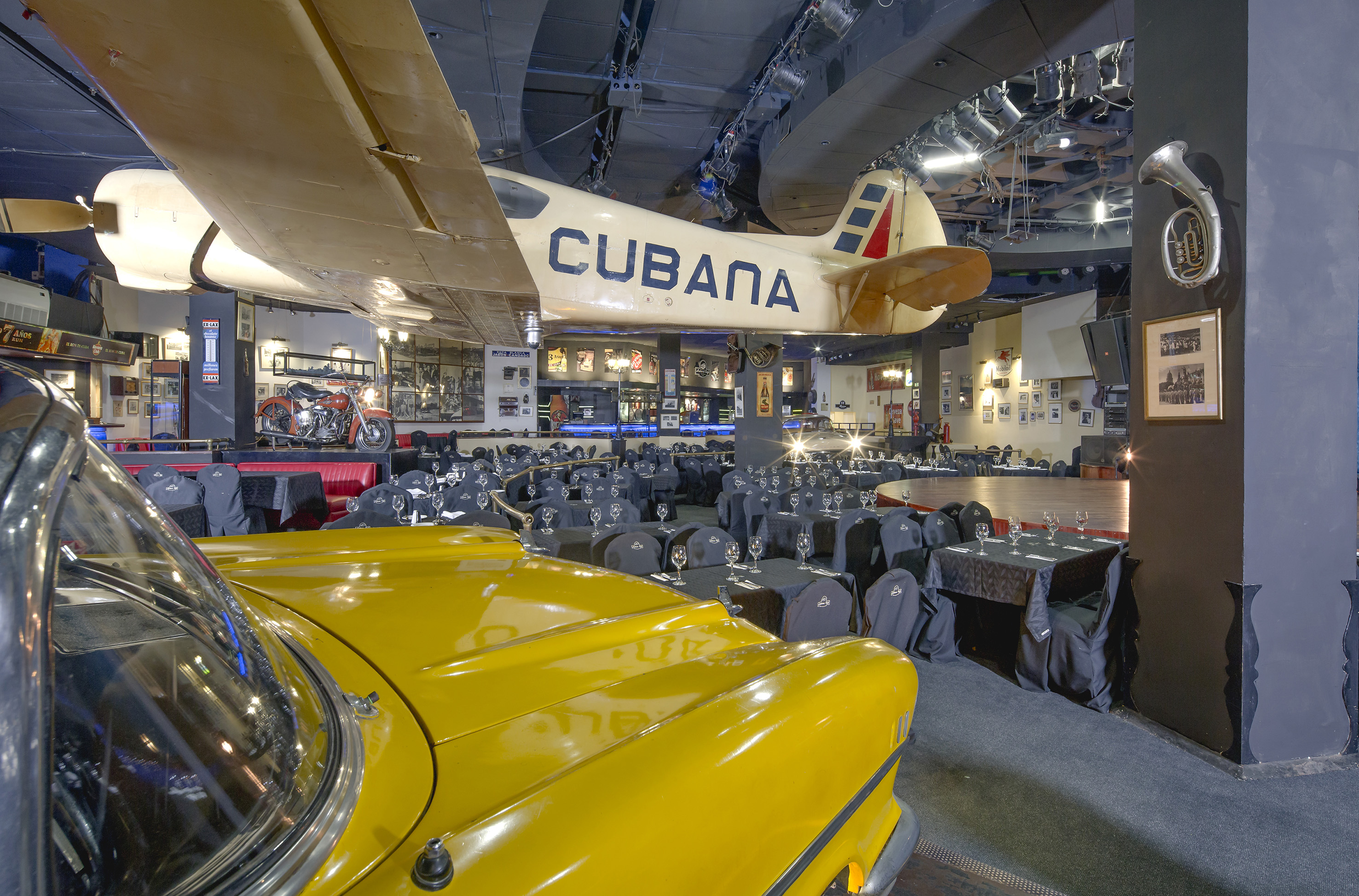 a room with tables and chairs and a yellow car