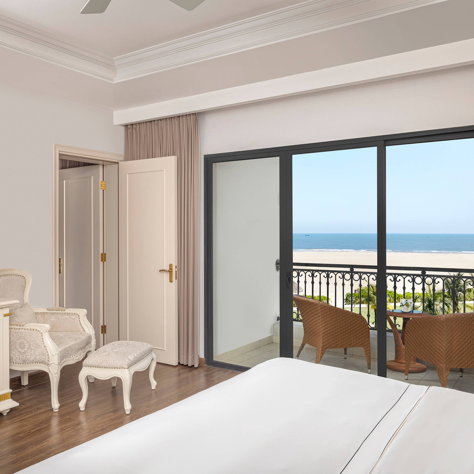 a bedroom with a balcony overlooking the ocean
