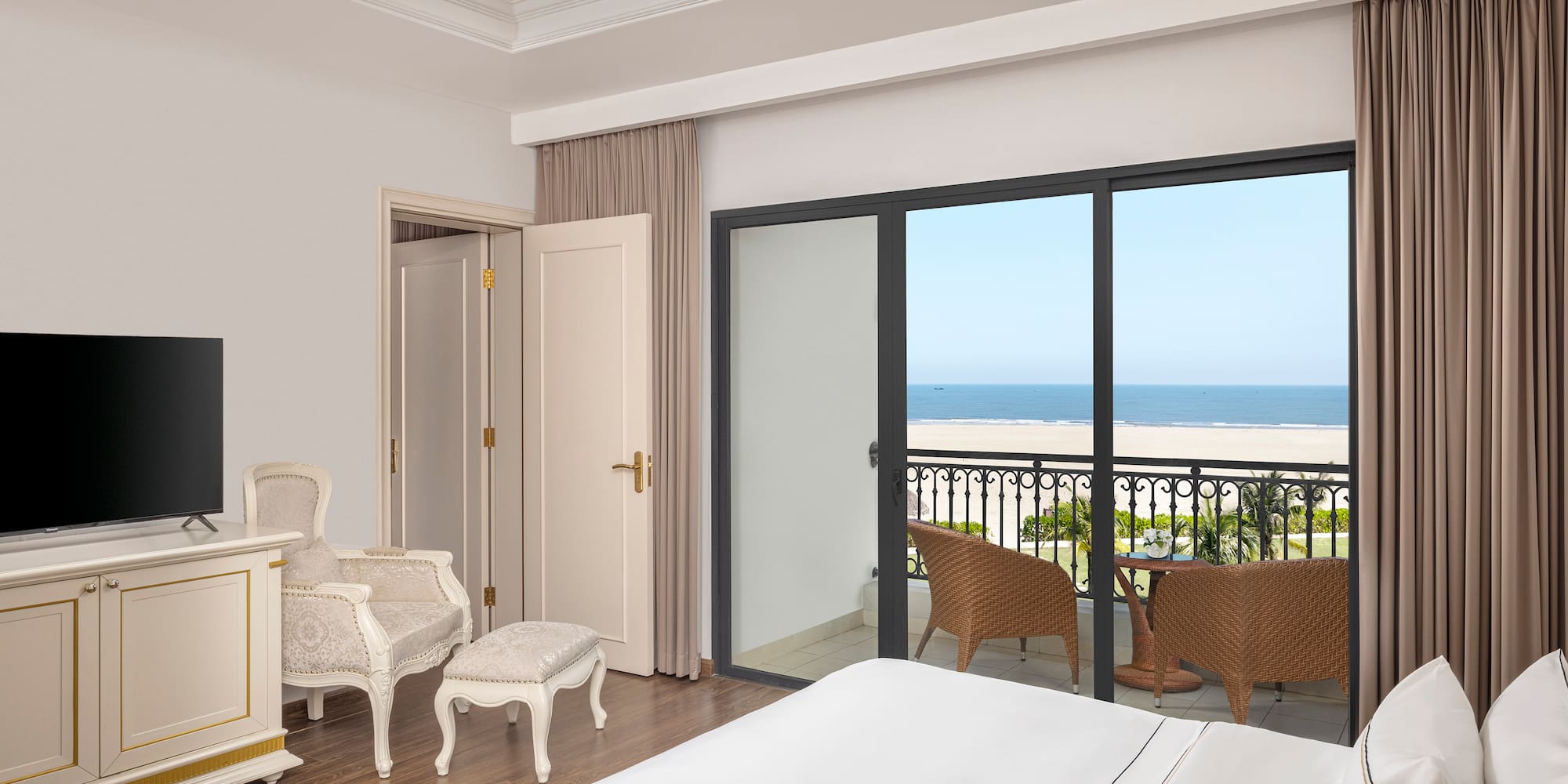 a bedroom with a balcony overlooking the ocean