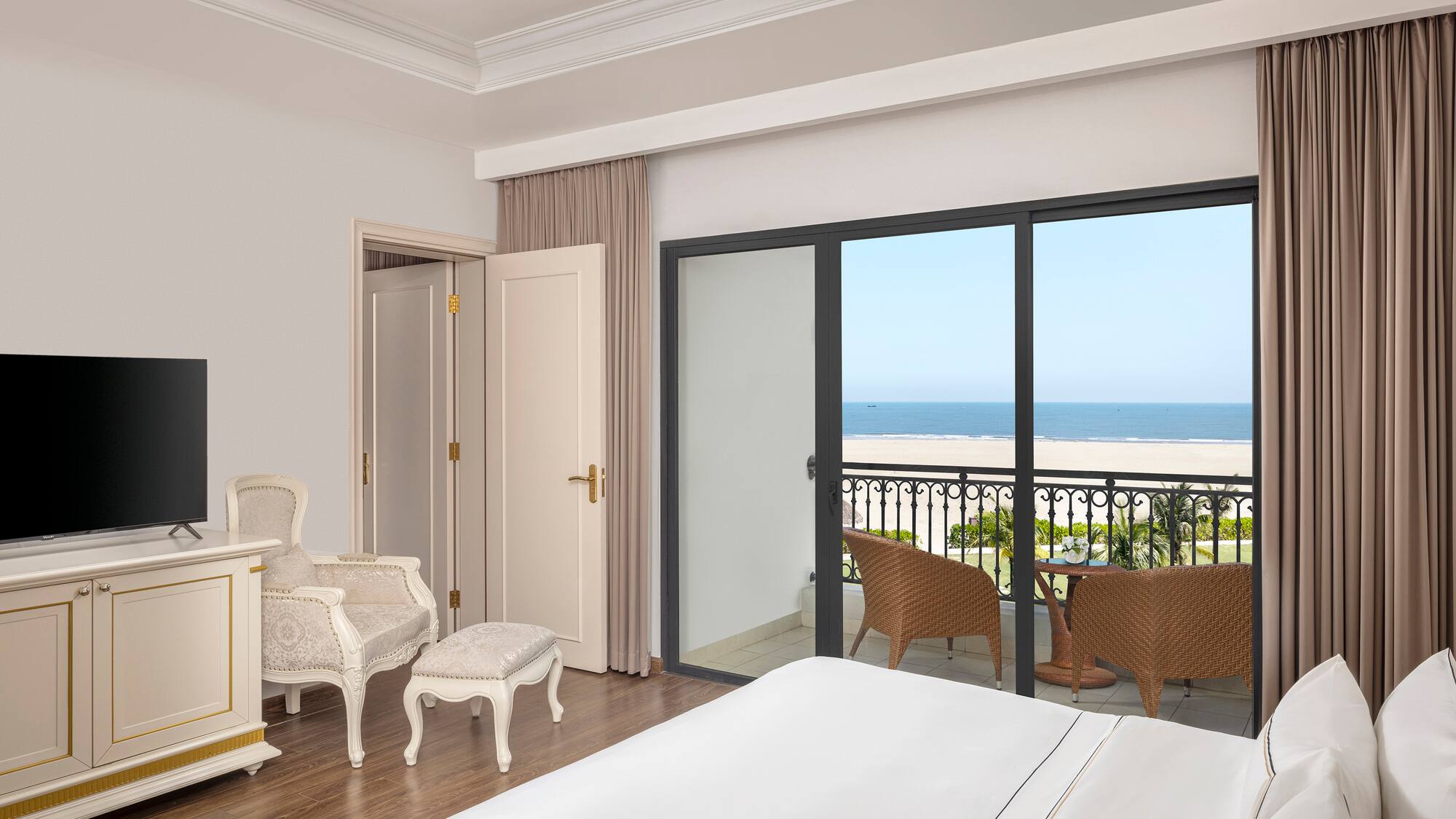 a bedroom with a balcony overlooking the ocean