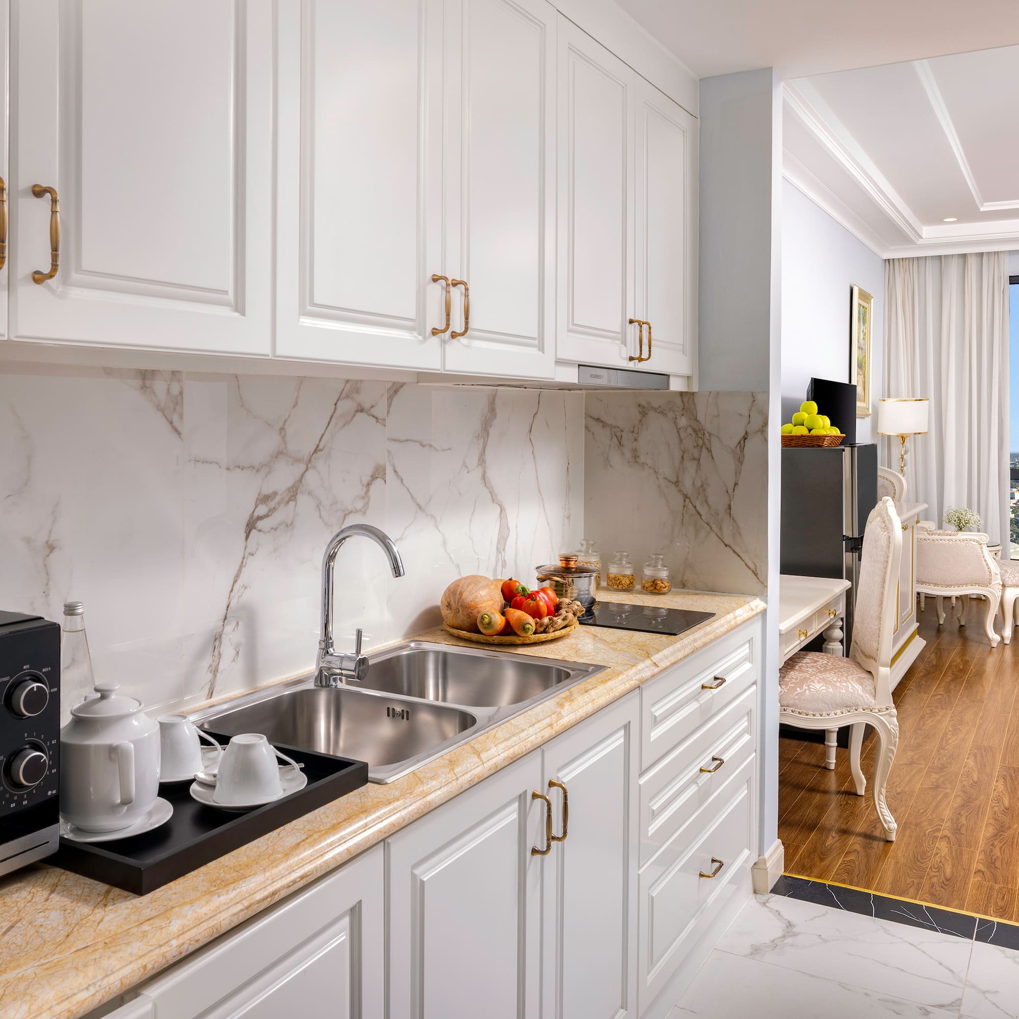 a kitchen with white cabinets and a marble countertop