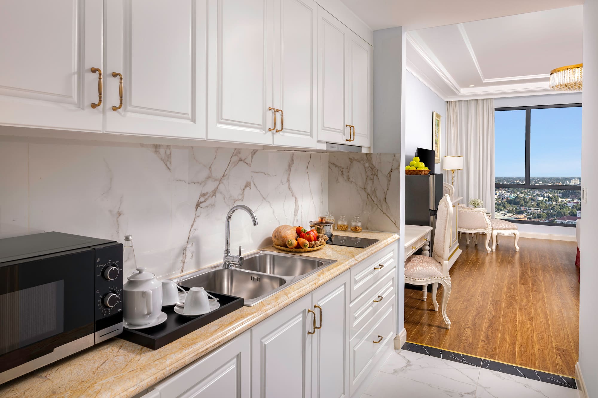 a kitchen with white cabinets and a marble countertop