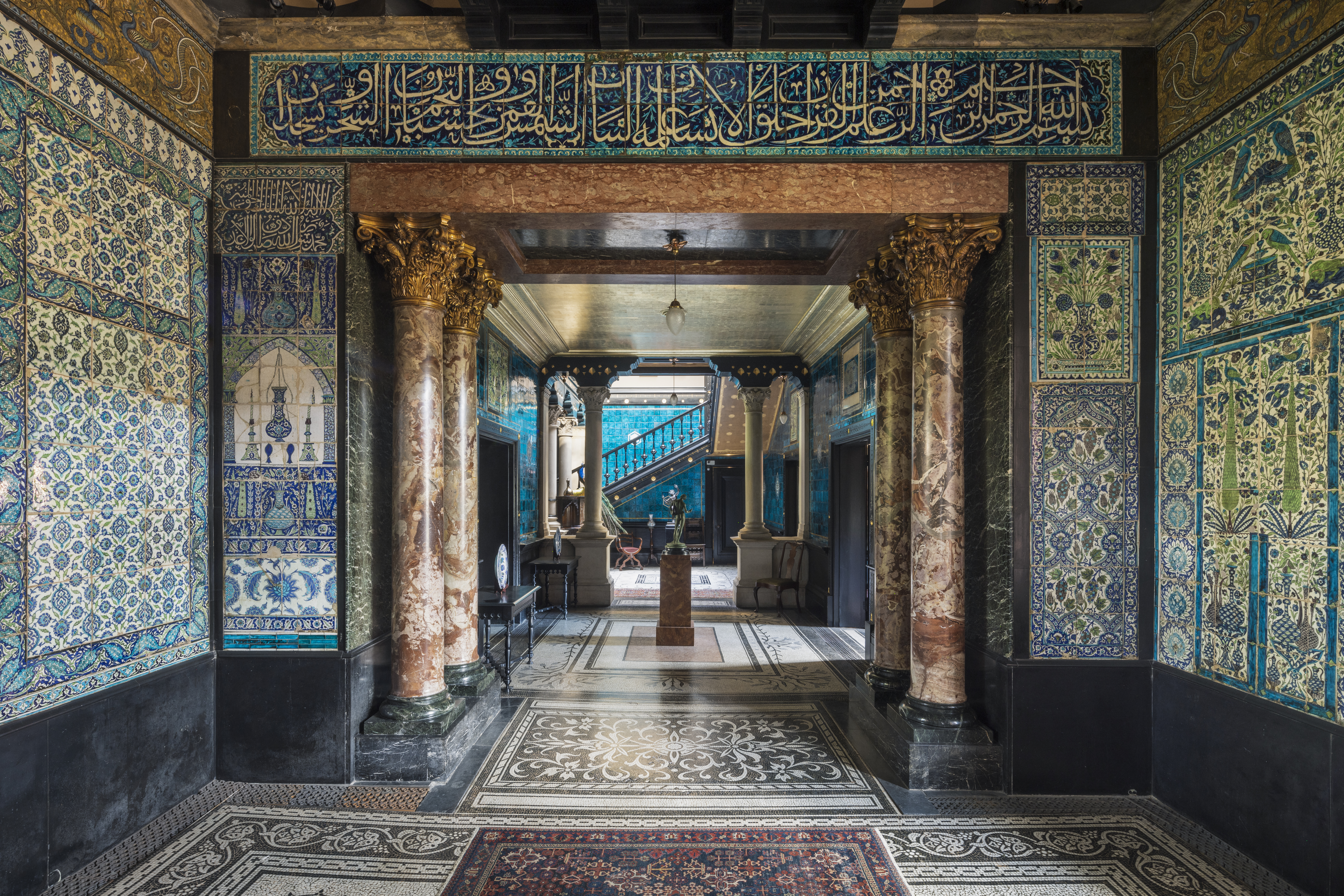 a hallway with ornate walls and a carpet
