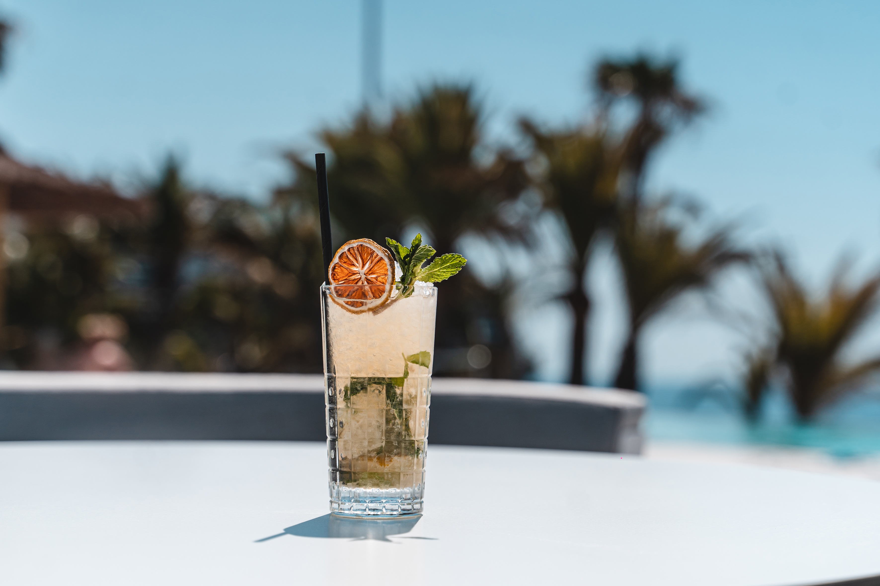 Refreshing summer cocktail with dried orange and mint at a resort.