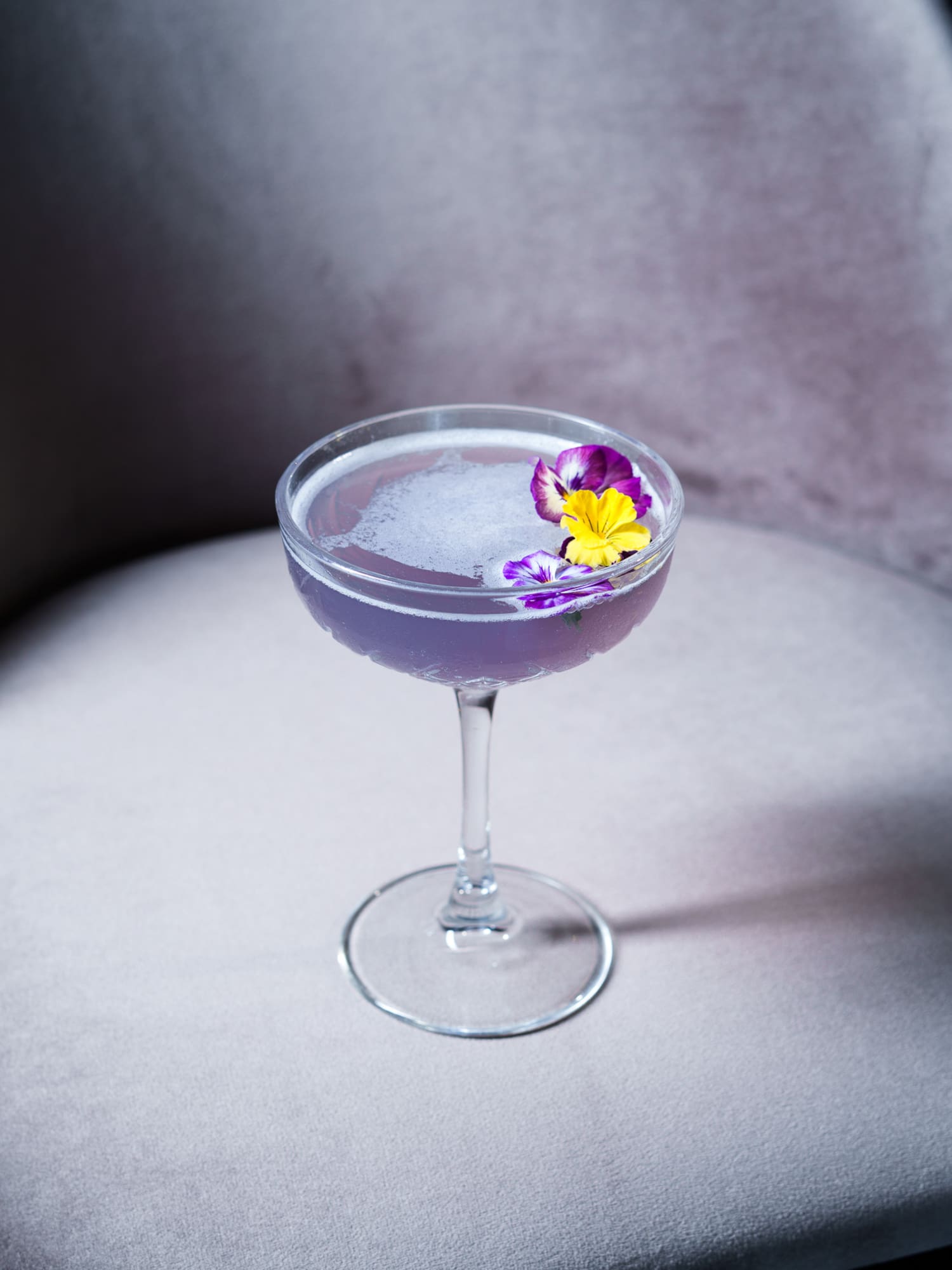 a glass with a drink and a flower on it