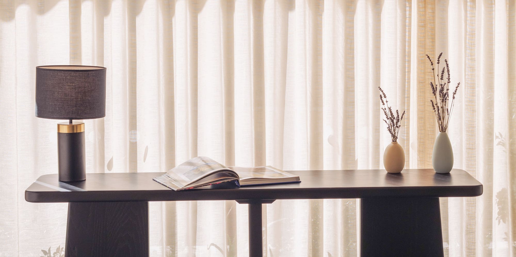 a table with a lamp and vases on it