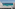 Modern balcony with glass railing, turquoise ocean view, and blue sky.