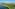 Tropical resort with palm-lined lake, white villas, and distant mountains.