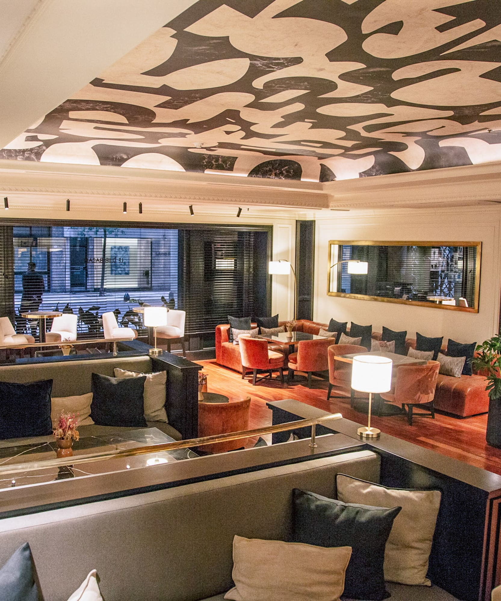 Lounge de hotel moderno con sofás, sillones y techo de diseño abstracto.