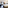 Spacious modern hotel room with king bed, wood floors, work desk, and large window.