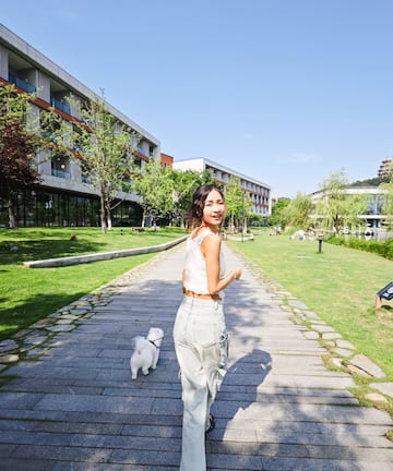 a woman walking a dog on a stone path