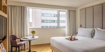 a hotel room with a bed and chairs