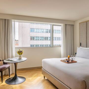 a hotel room with a bed and chairs