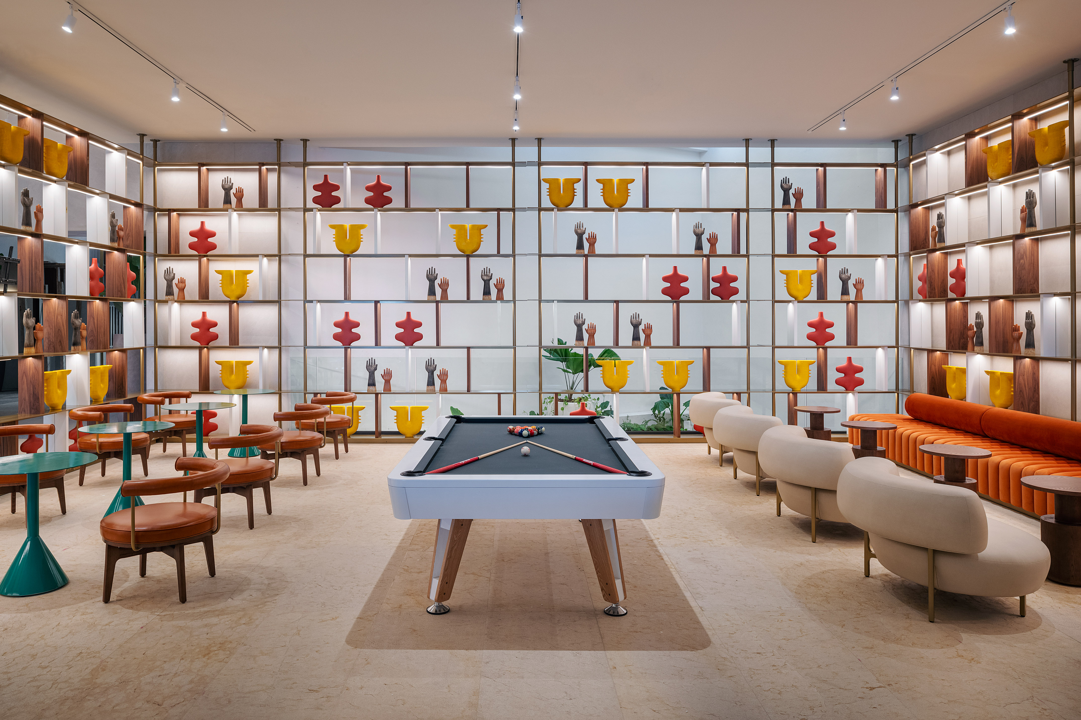 Modern lounge with pool table, stylish seating, and colorful abstract wall art.