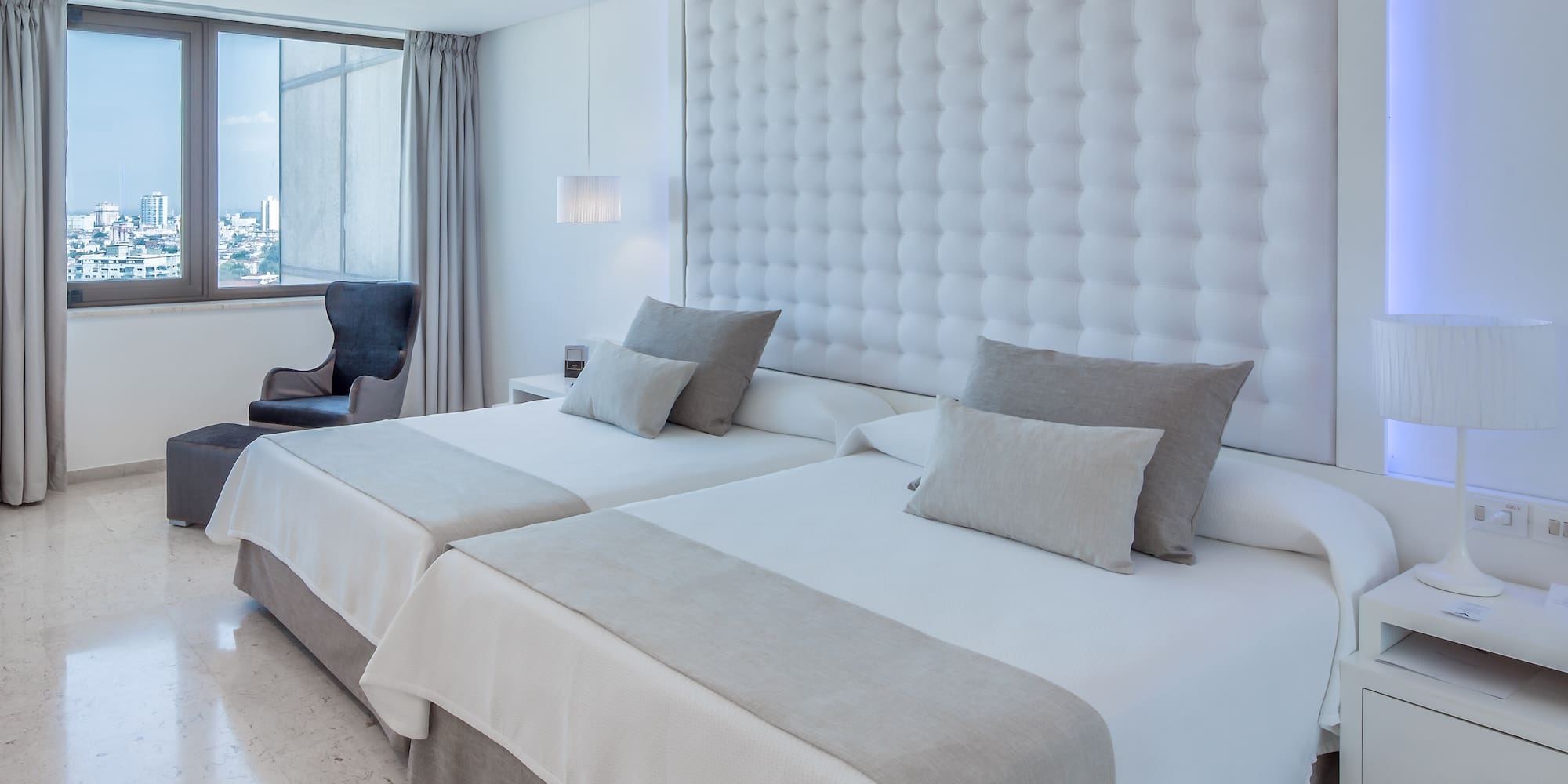 a room with two beds and a chair