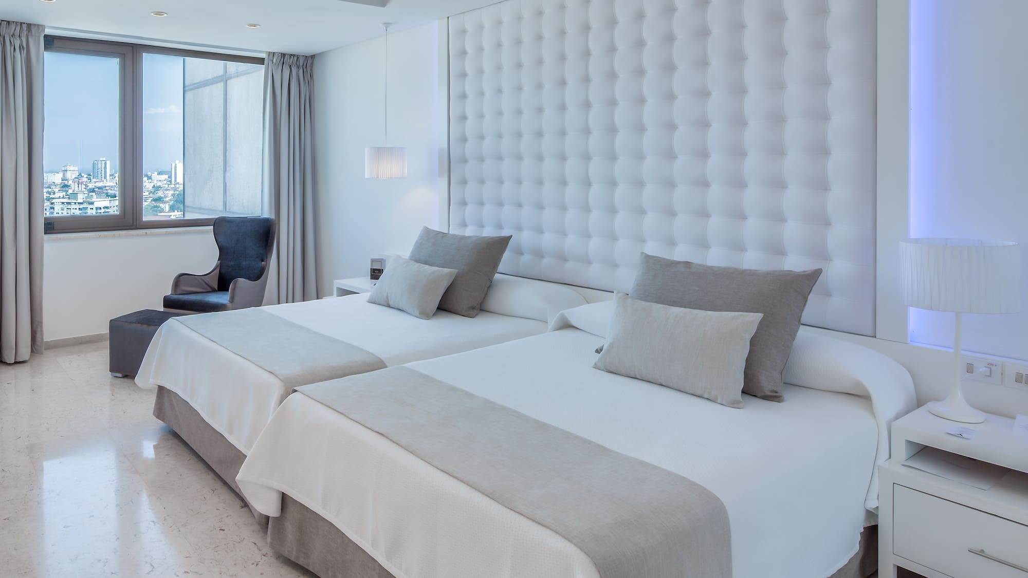 a room with two beds and a chair