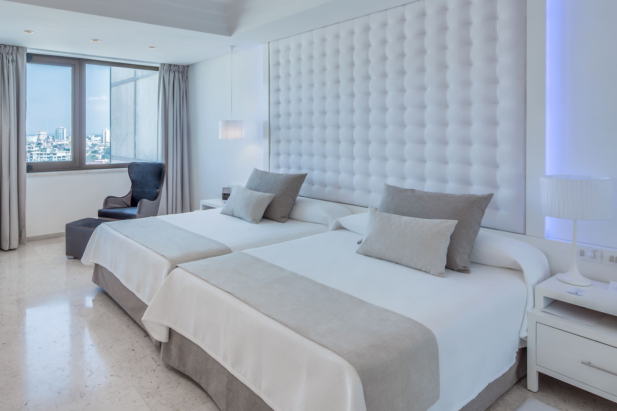 a room with two beds and a chair