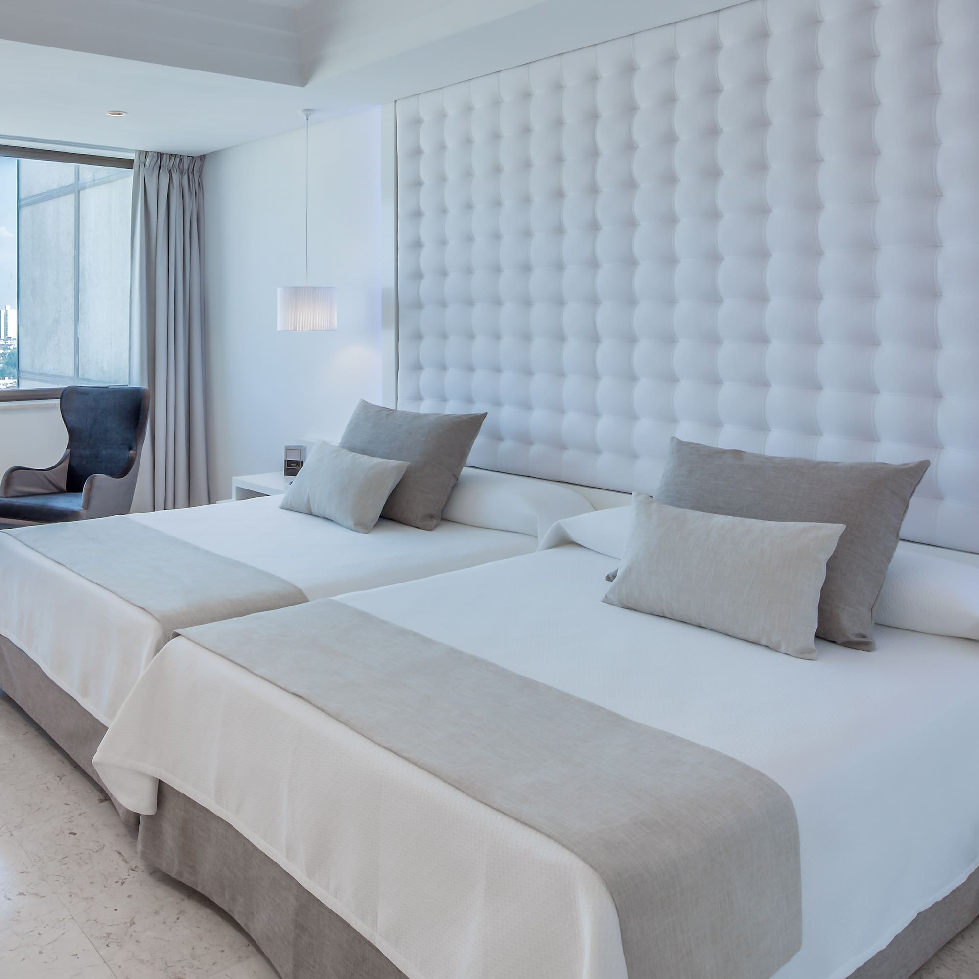 a room with two beds and a chair