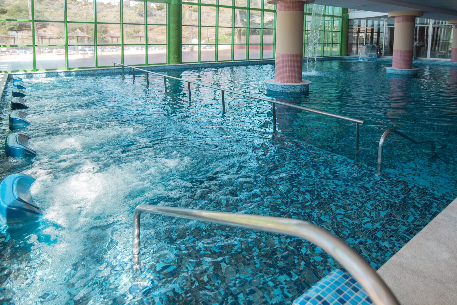 a large indoor pool with stairs and railings