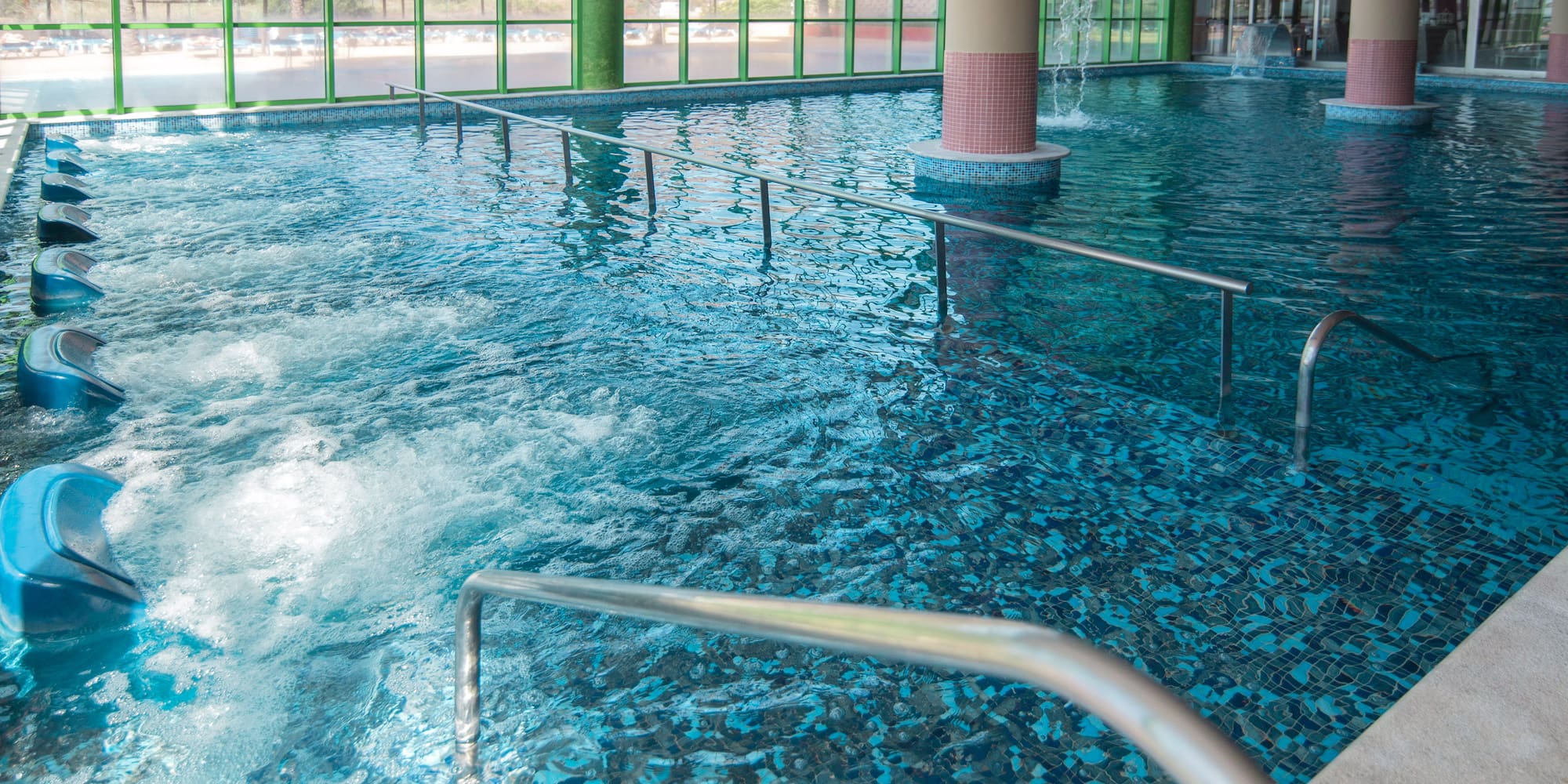 a large indoor pool with stairs and railings