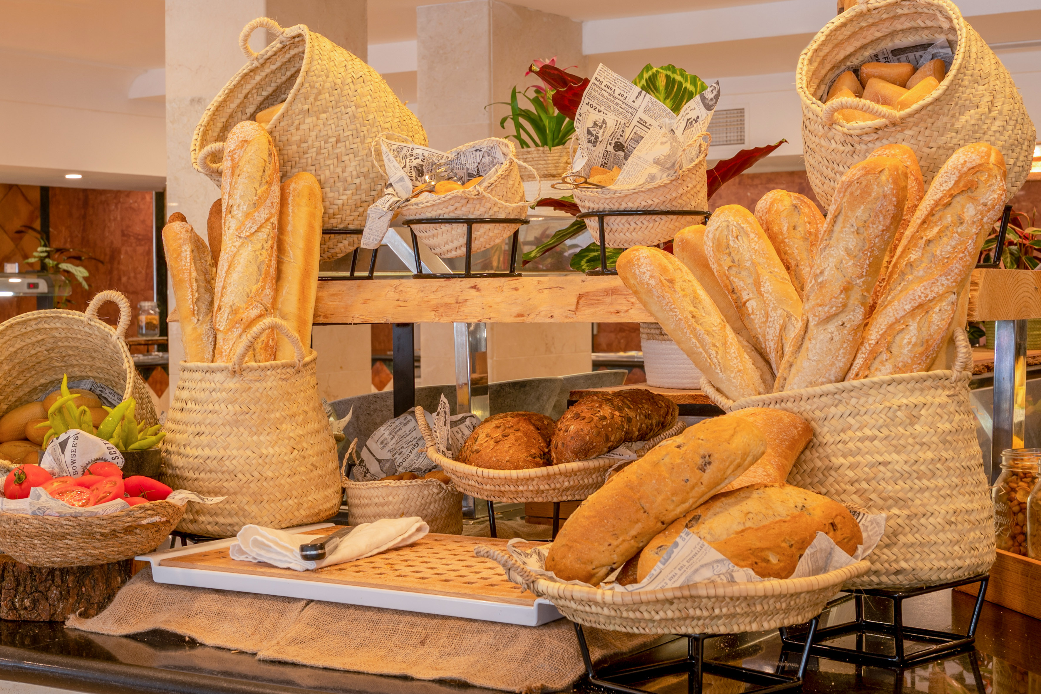 Assortment of fresh baked bread, baguettes, and rolls in wicker baskets.