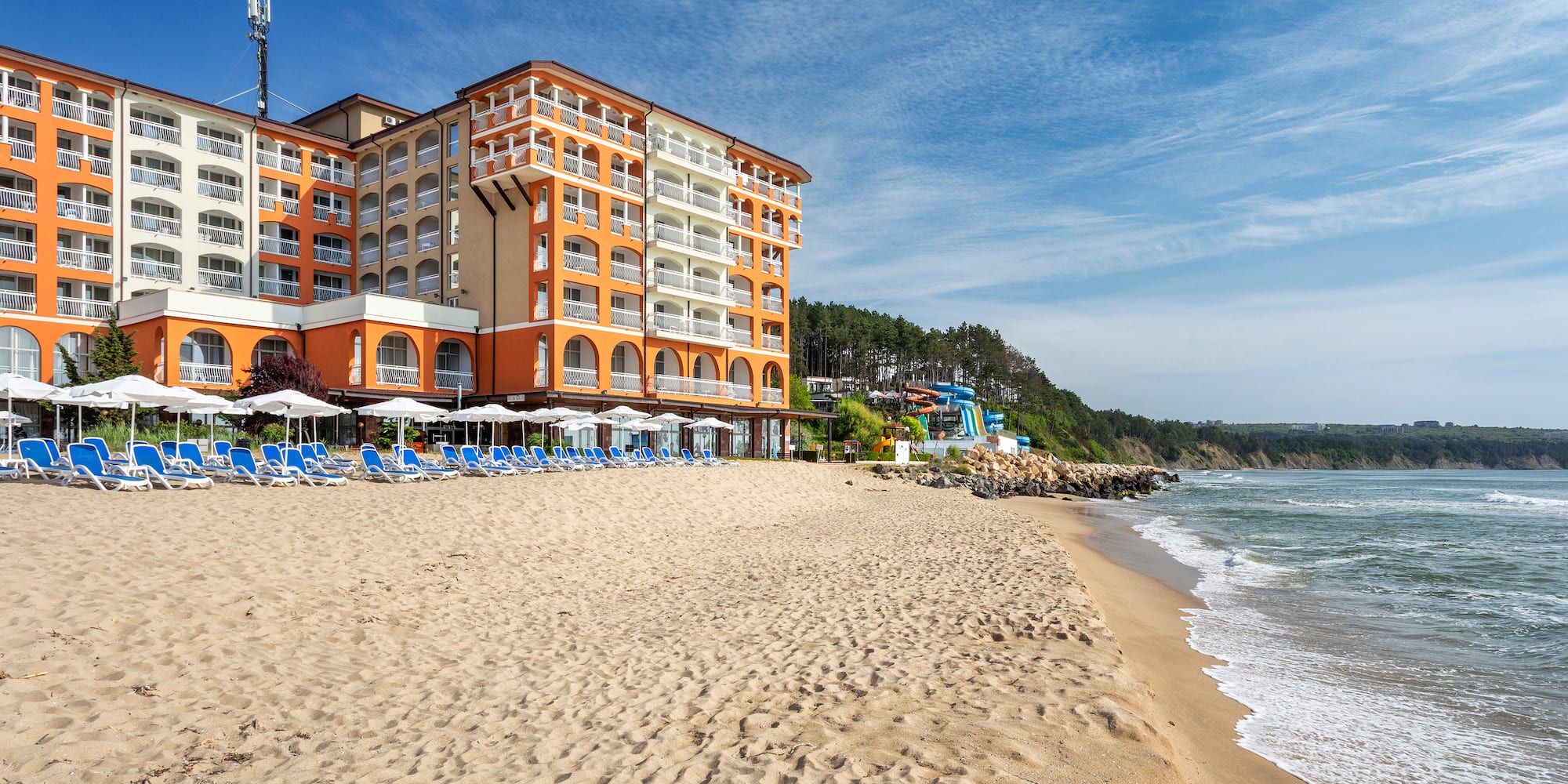 a beach with a building and chairs