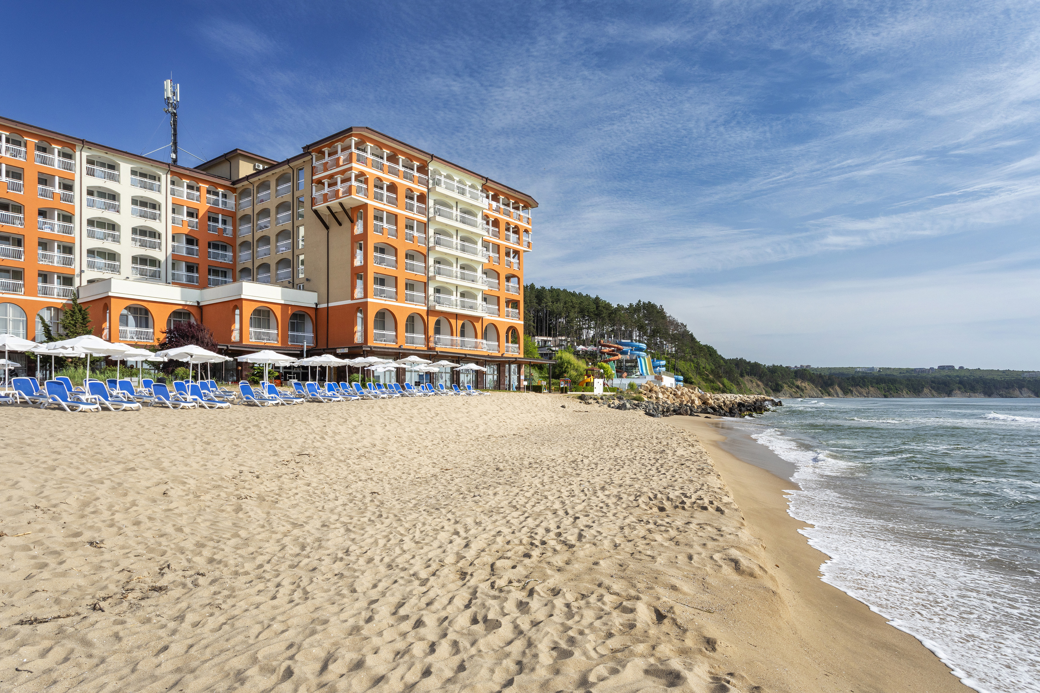 a beach with a building and chairs