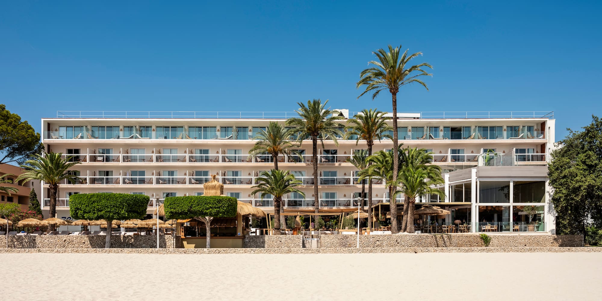 a building with palm trees and a beach