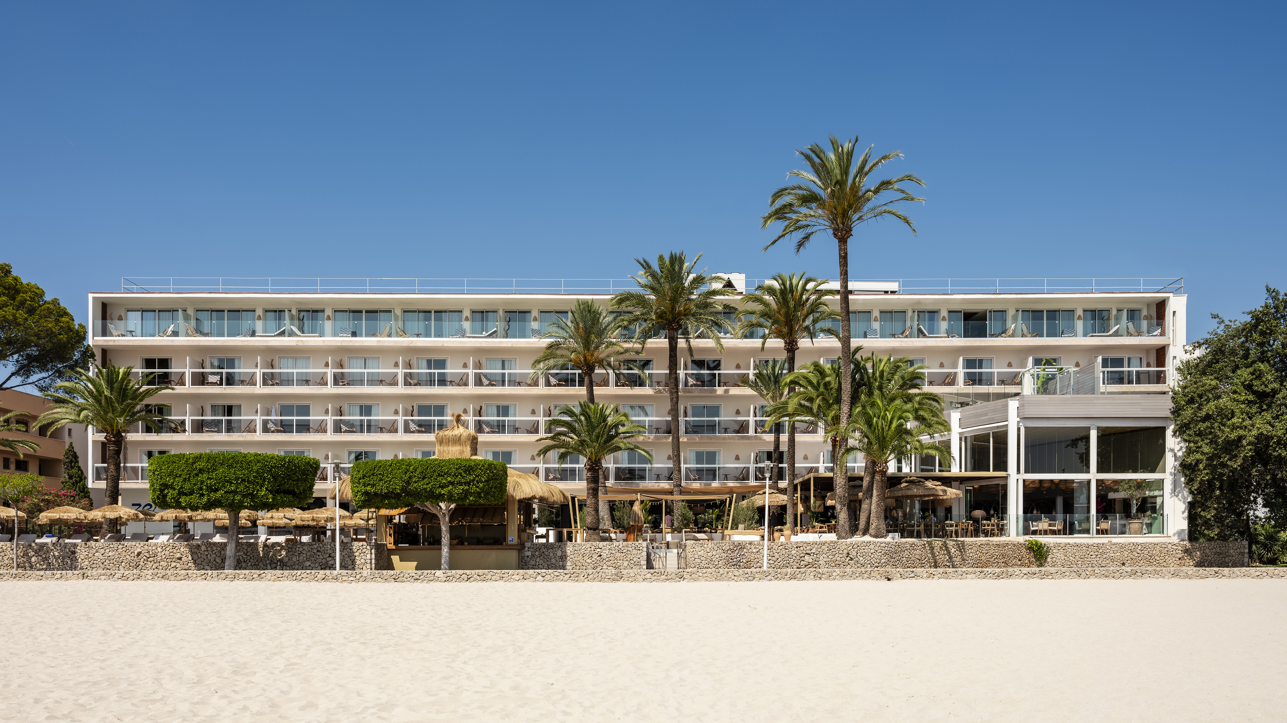 a building with palm trees and a beach