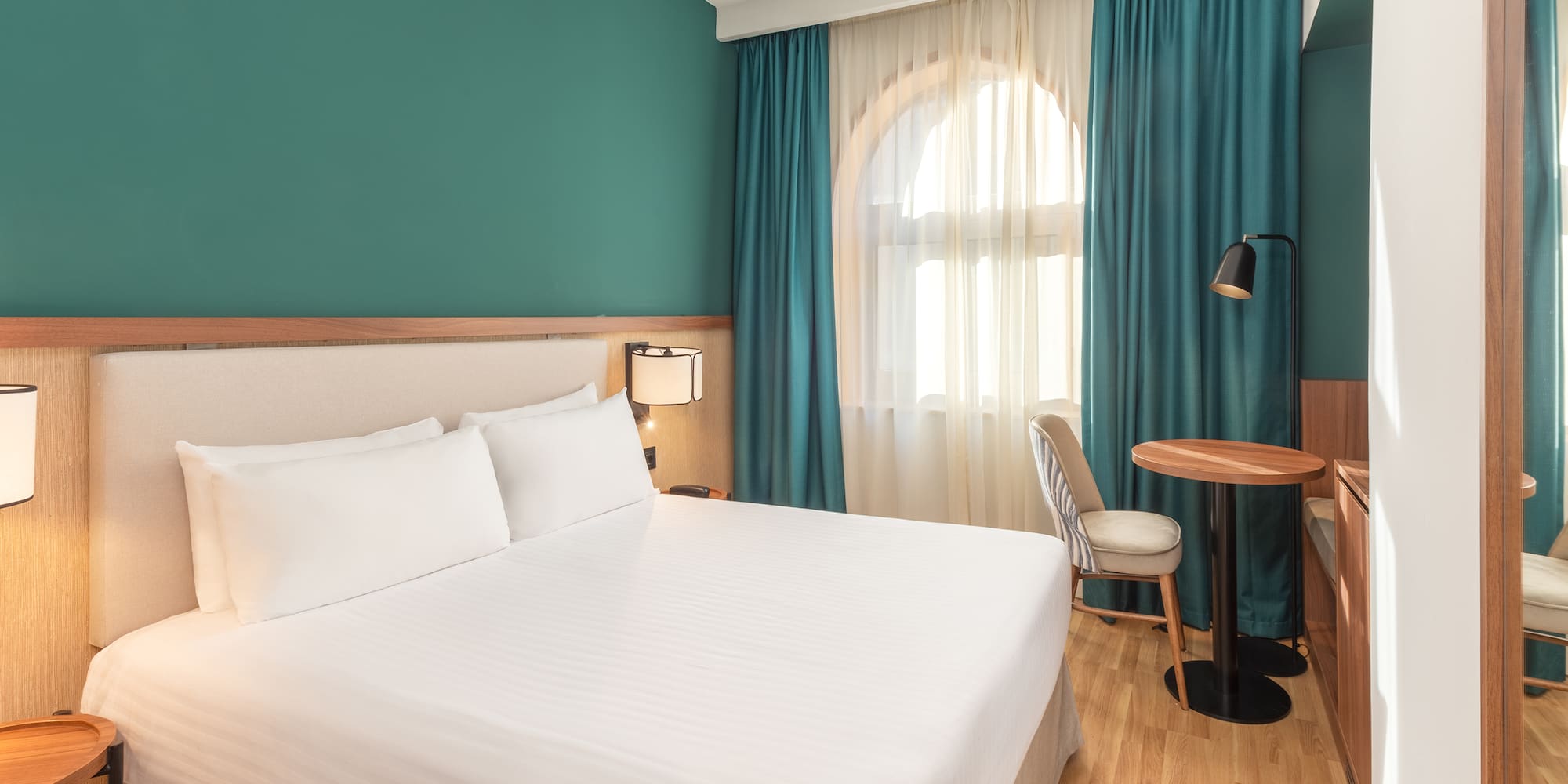 a room with a bed and a table and chairs