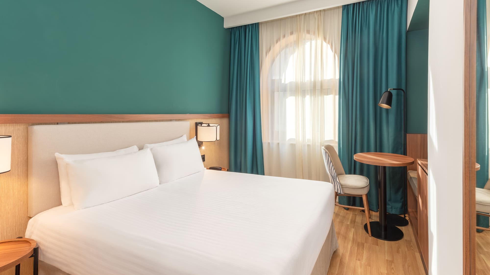 a room with a bed and a table and chairs