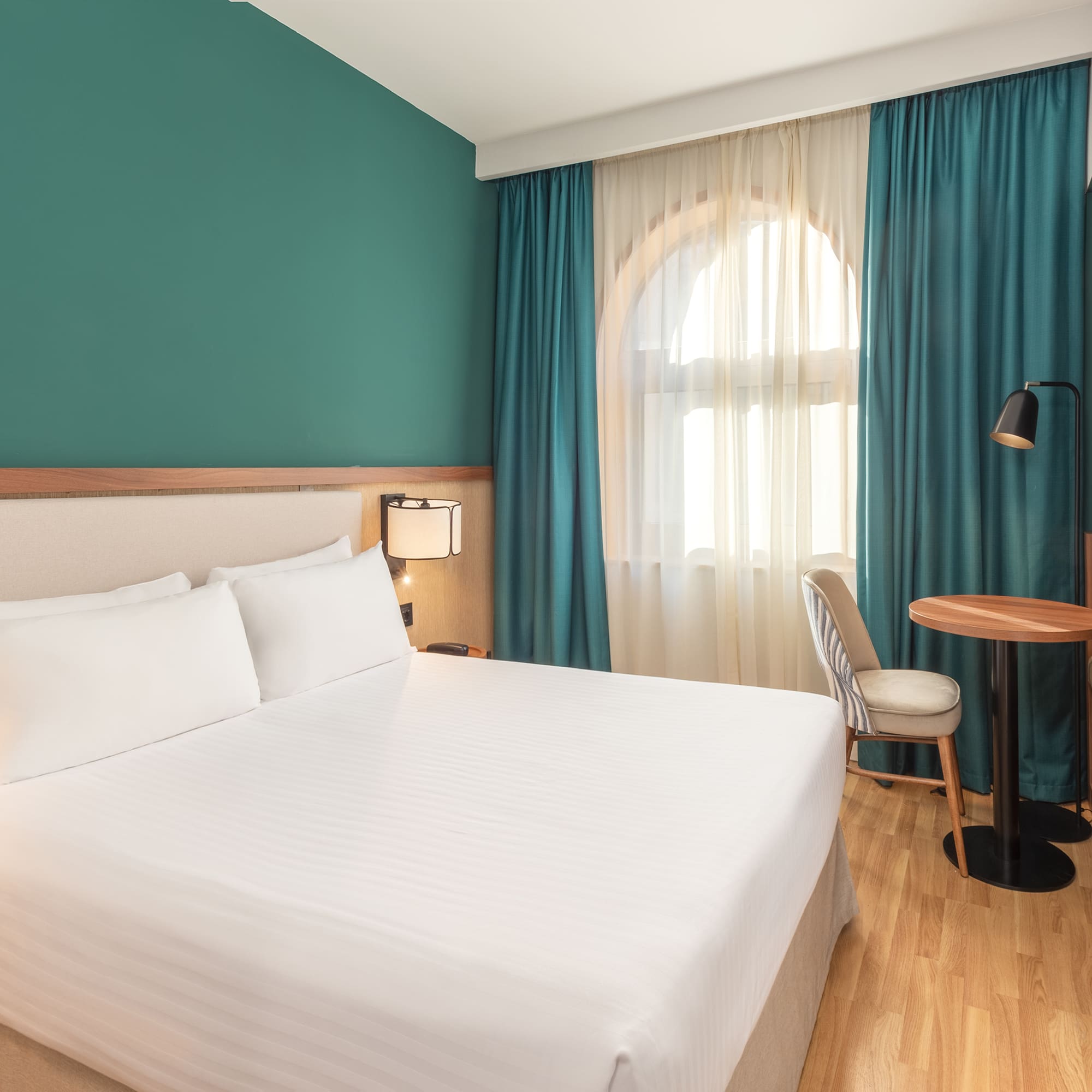 a room with a bed and a table and chairs