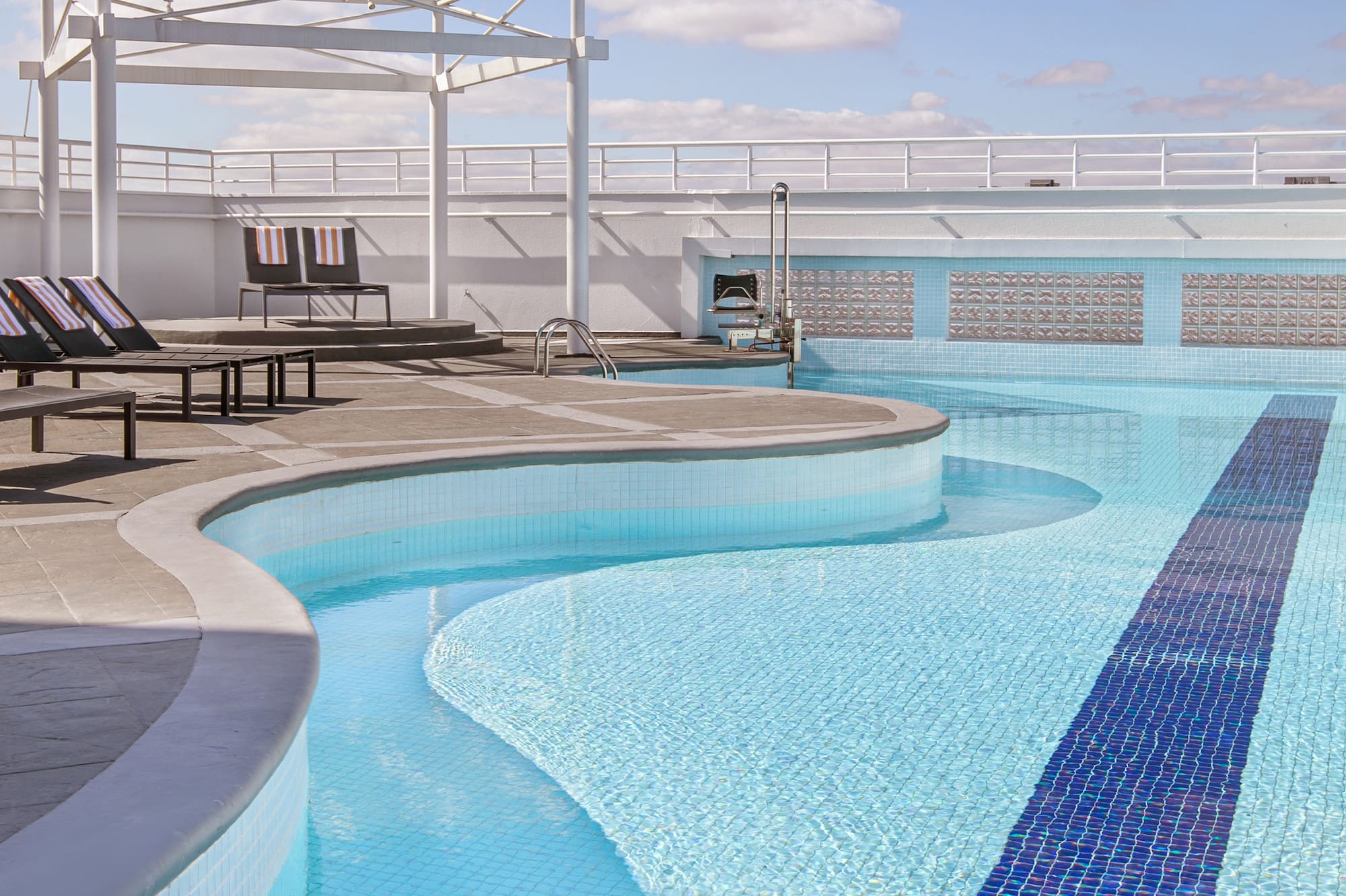 a pool with chairs and a roof over it