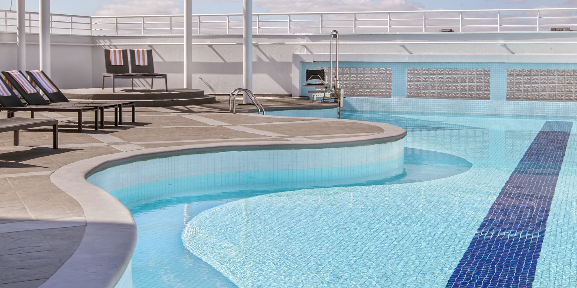 a pool with chairs and a roof over it